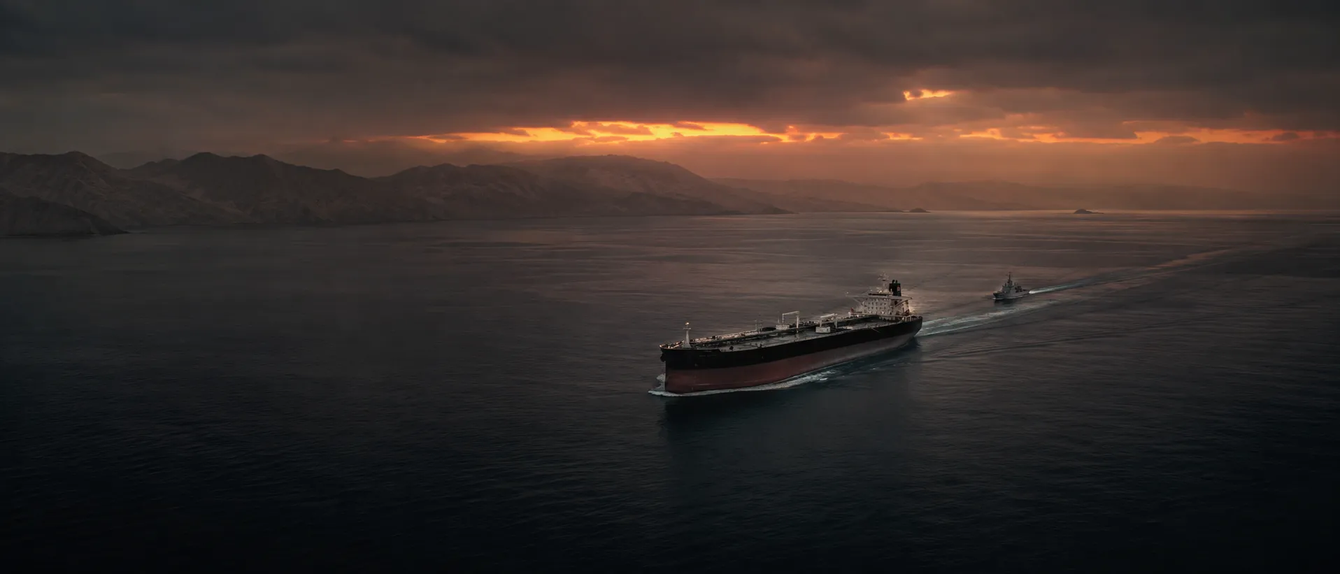 Petrolero con escolta naval cruzando el estrecho de Ormuz al atardecer en medio de tensiones persistentes